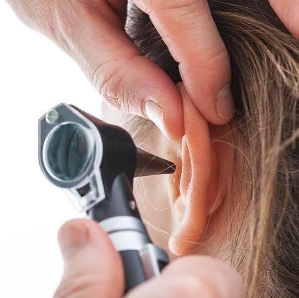 Inspecting a patient's ear with an Otoscope